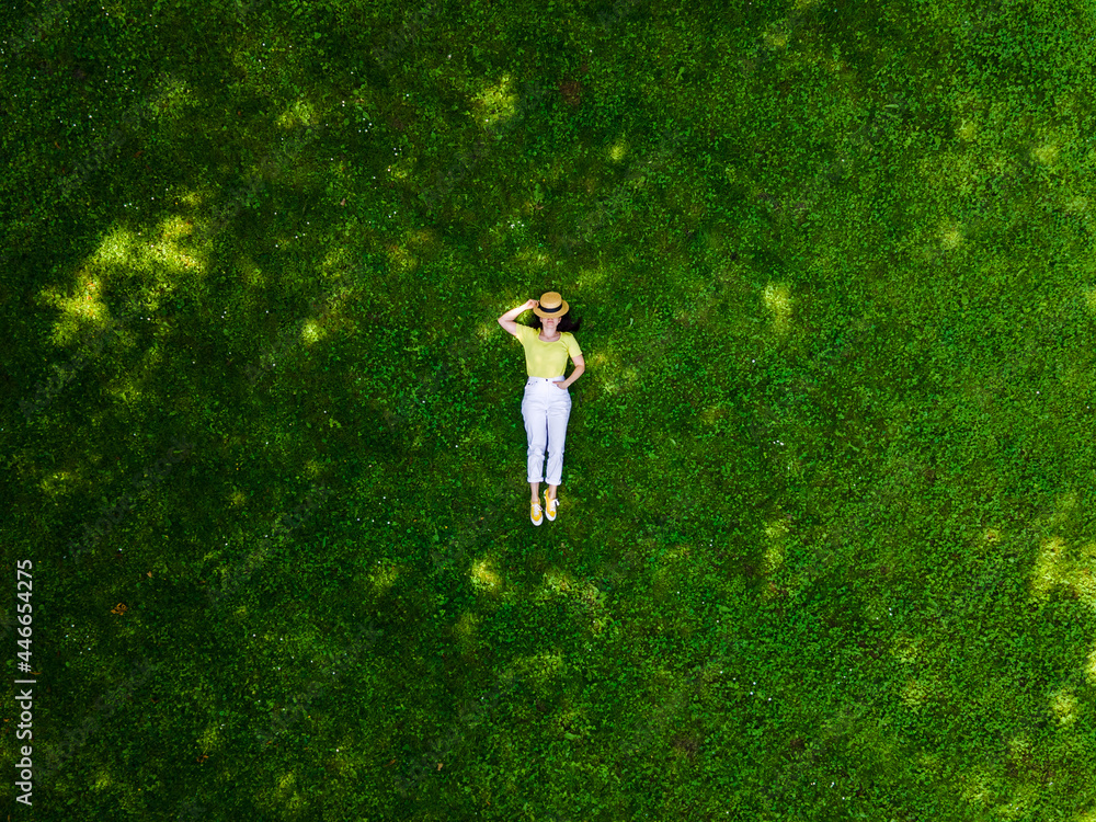 overhead view of woman laying down on green grass