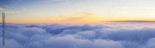 Panoramic view above clouds with beautiful sunset. © Jag_cz