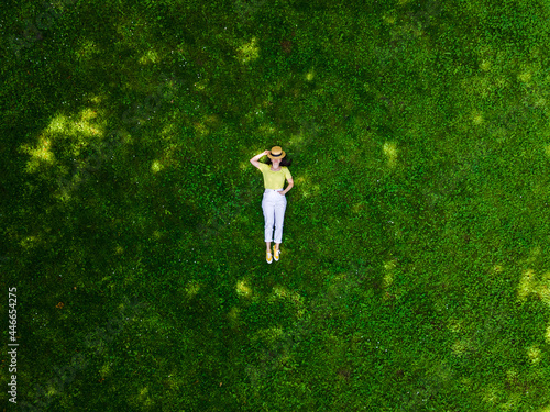 Obraz na płótnie overhead view of woman laying down on green grass w salonie