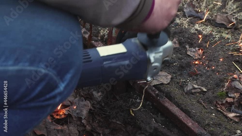Wallpaper Mural Man's hands are cutting the old, destroyed metal structure with a grinder. Dismantling of a greenhouse collapsed from snow on a personal plot. Working with metal with an electric cutting tool. UHD 4K. Torontodigital.ca