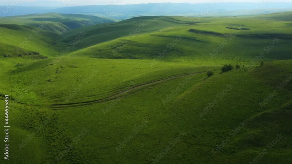 Drone Flight above long dirt road in the green fields . Aerial view on the beautiful summer landscape with country road and green fields Drone Flight above long dirt road in the green fields . Aerial view on the beautiful summer landscape with country road and green fields