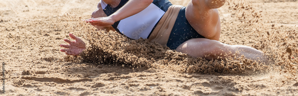 Young athletic woman in long jump. Horizontal sport poster, greeting cards, headers, website Young athletic woman in long jump. Horizontal sport poster, greeting cards, headers, website