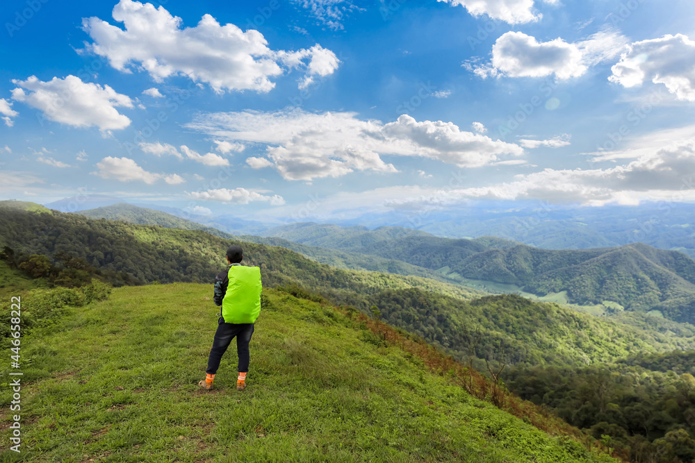 Man hiking at mountains with heavy backpack Travel Lifestyle wanderlust adventure concept summer vacations outdoor alone into the wild. Man enjoying the view of the Valley.