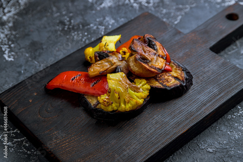 grilled vegetables on a black wooden board