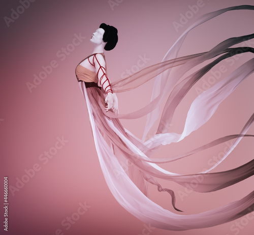 Levitating geisha wearing a ceremonial dress creating voluptuousness in the wind