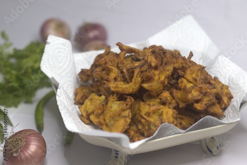 Onion fritters. Deep fried onions slices coated with ground flour and masala. A popular snack in India commonly known as onion pakoda photo