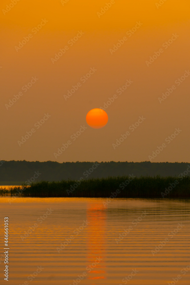 sunset at coast of the lake. Nature landscape. Nature in northern Europe. reflection, blue sky and yellow sunlight. landscape during sunset. sunset at coast of the lake. Nature landscape. Nature in northern Europe. reflection, blue sky and yellow sunlight. landscape during sunset.