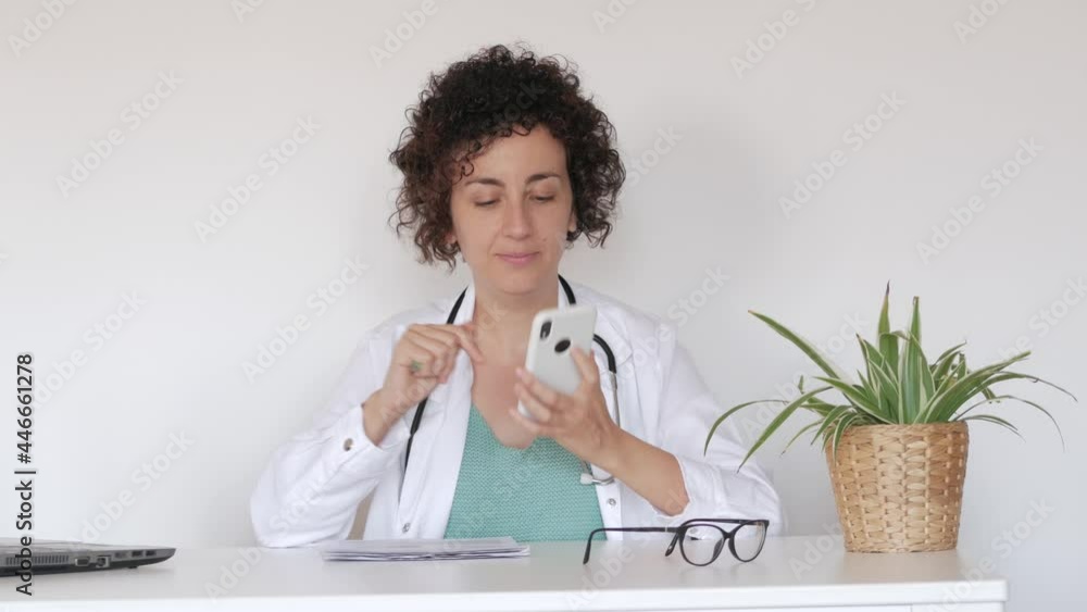 Insurance female doctor answering a phone call in his office Insurance female doctor answering a phone call in his office