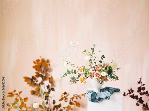 Obraz na plátně asymmetrical floral arrangement on stand in front of pink background