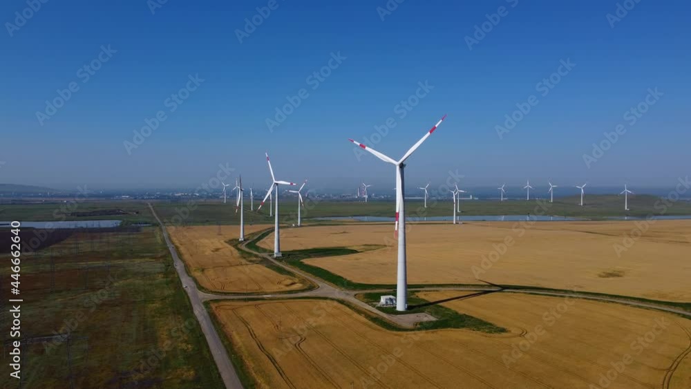Wind energy working in the field. Green eco-friendly energy. Blue sky. Moving the camera up Wind energy working in the field. Green eco-friendly energy. Blue sky. Moving the camera up
