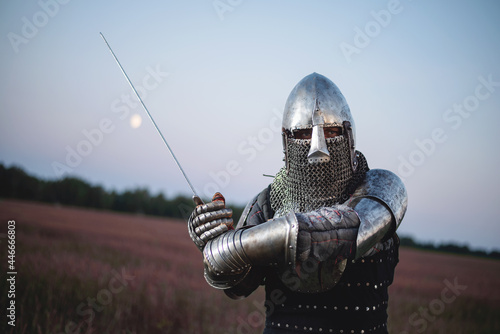 A knight with a sword battles on the battlefield on a dark sky background Fotobehang