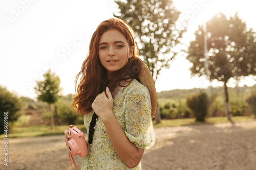 Pretty young lady in floral dress enjoying a walk otdoors on a sunny day photo