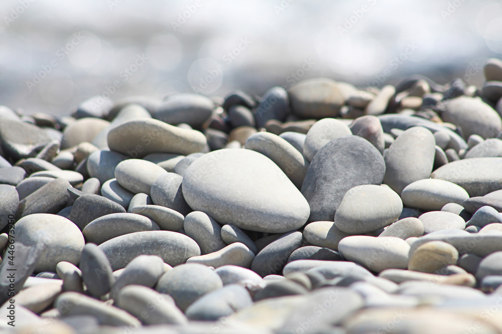 Sea pebble stones. Blurred out of focus sun lights bokeh natural background, wallpaper. Sea pebble stones. Blurred out of focus sun lights bokeh natural background, wallpaper.