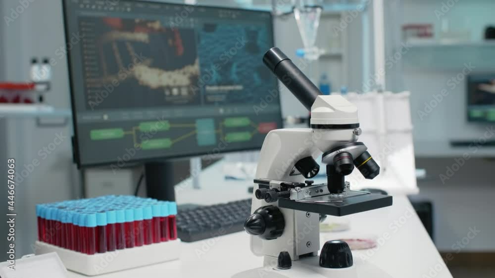 Close up of laboratory microscope on desk with medical research instruments. Empty room with micropipette, vacutainers and computer as modern technology equipment used for experiment Close up of laboratory microscope on desk with medical research instruments. Empty room with micropipette, vacutainers and computer as modern technology equipment used for experiment