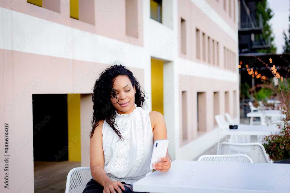 young latin woman on terrace with her white smartphone young latin woman on terrace with her white smartphone