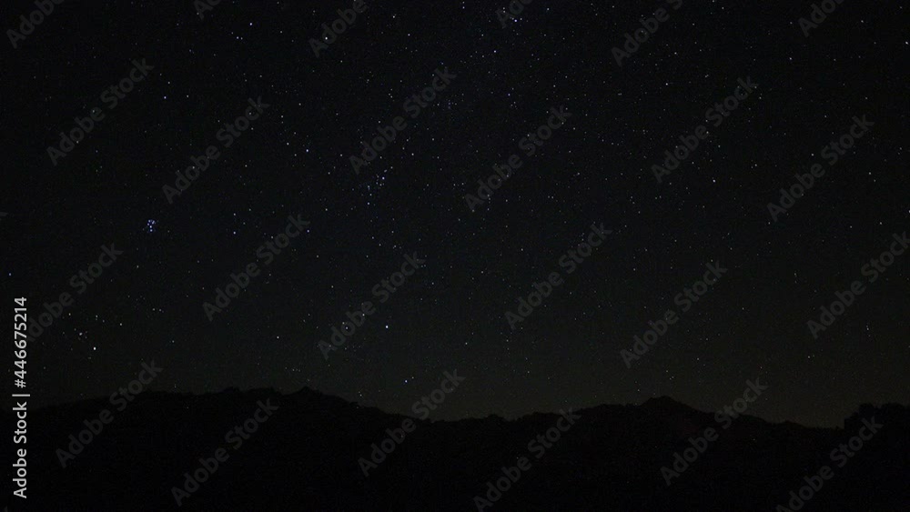 Timelapse of moving star trails in night sky. A view of the stars of the Milky Way with a mountain top in the foreground. Night sky nature summer landscape. Perseid Meteor Shower observation. Timelapse of moving star trails in night sky. A view of the stars of the Milky Way with a mountain top in the foreground. Night sky nature summer landscape. Perseid Meteor Shower observation.