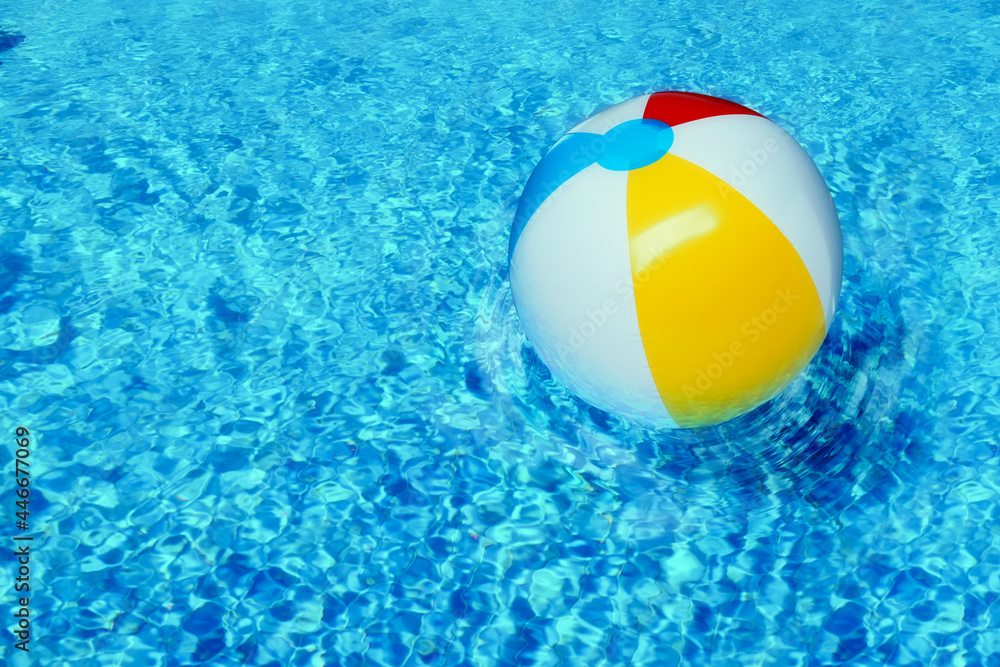 Inflatable beach ball floating in swimming pool