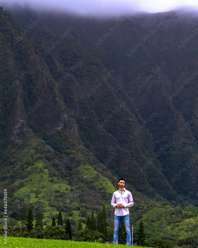 Man standing in front of mountains in Hawaii
