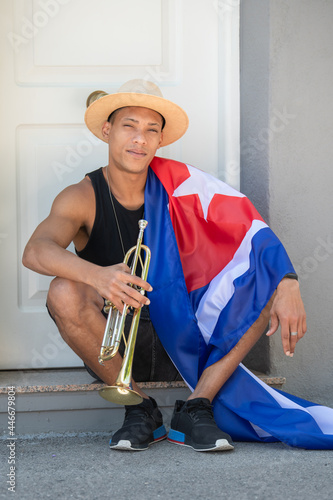 Latino man with the cuban flag holding a trumpet: Selective focus Music and diversity concept. photo