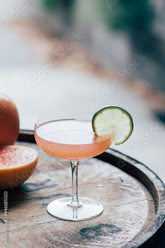grapefruit Hemingway daiquiri cocktail with lime wheel in coupe glass on whiskey barrel  photo