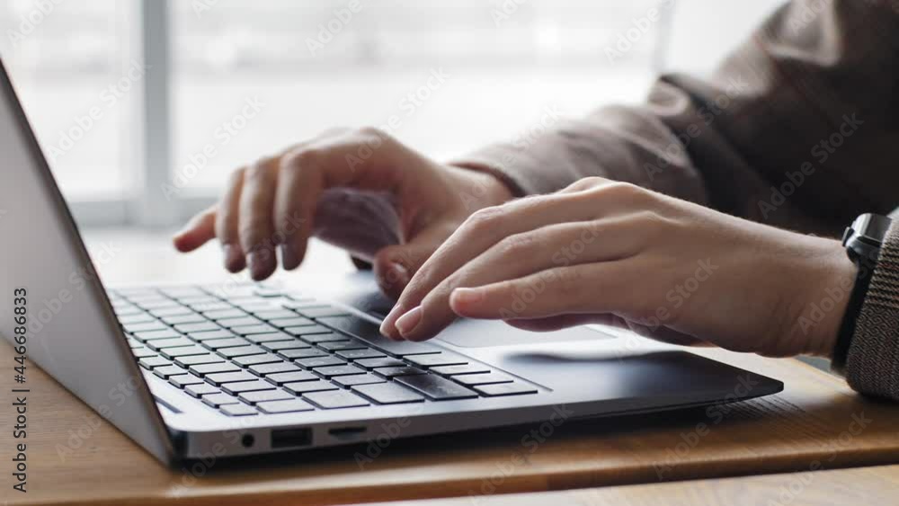 Close-up female hands of caucasian student girl typing on laptop keyboard at table in home office. Unrecognizable woman wears jacket and electronic watch on wrist working at computer chatting online Close-up female hands of caucasian student girl typing on laptop keyboard at table in home office. Unrecognizable woman wears jacket and electronic watch on wrist working at computer chatting online