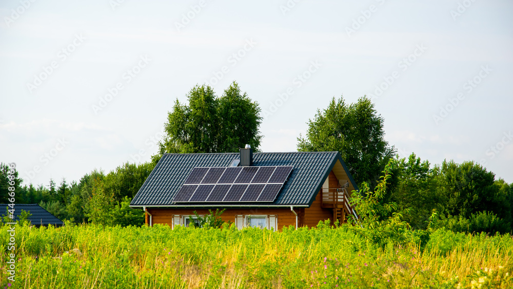 ecological wooden house with solar panels on a sunny day ecological wooden house with solar panels on a sunny day