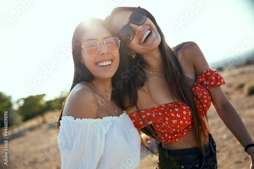 Two smiling young women talking anad laughing while enjoying summer on road trip. photo