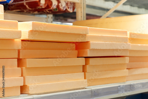 Stacks of orange styrofoam on a shelf in a hardware store.