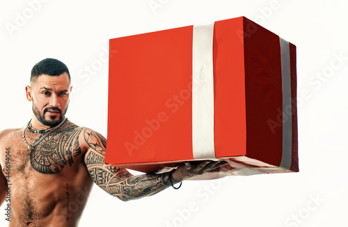 Sexy man with presetn box. big shopping sale. brutal sportsman torso. steroids. sport and fitness, health. muscular macho man with athletic body. confidence charisma. sexy abs of tattoo man. photo