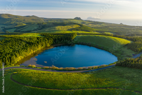 Aerial view of Lagoa da Lomba, a small lake surrounded with vegetation at sunset on Ilha das Flores, Azores islands, Portugal. photo