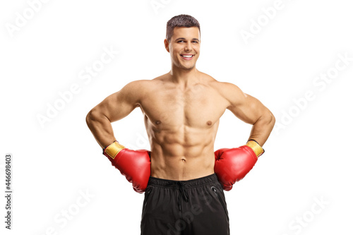 Shirtless male boxer with gloves smiling at camera