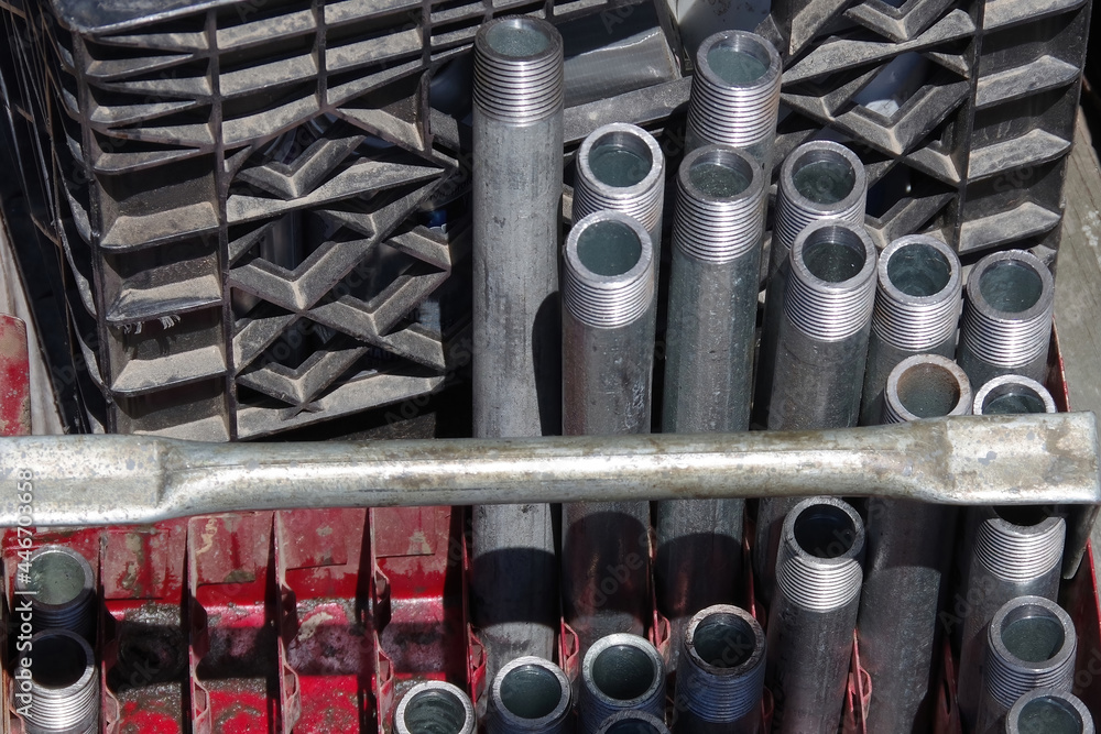 Close-up view of containers with a variety of threaded water pipes