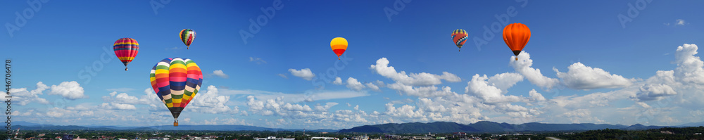 panorama of color hot air balloons in blue sky over the city background.