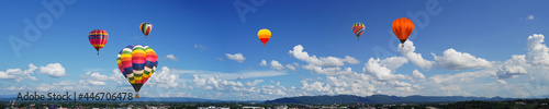 panorama of color hot air balloons in blue sky over the city background.