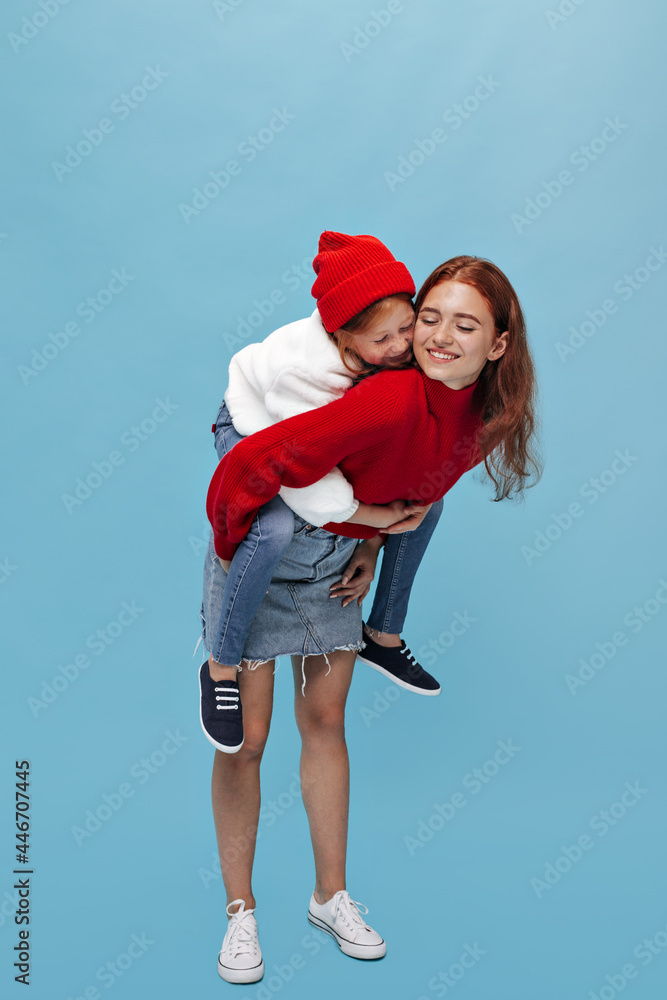Obraz premium Full length photo women in wide sweater and modern sneakers hugs and smiling on isolated background. Modern girls in bright clothes posing..