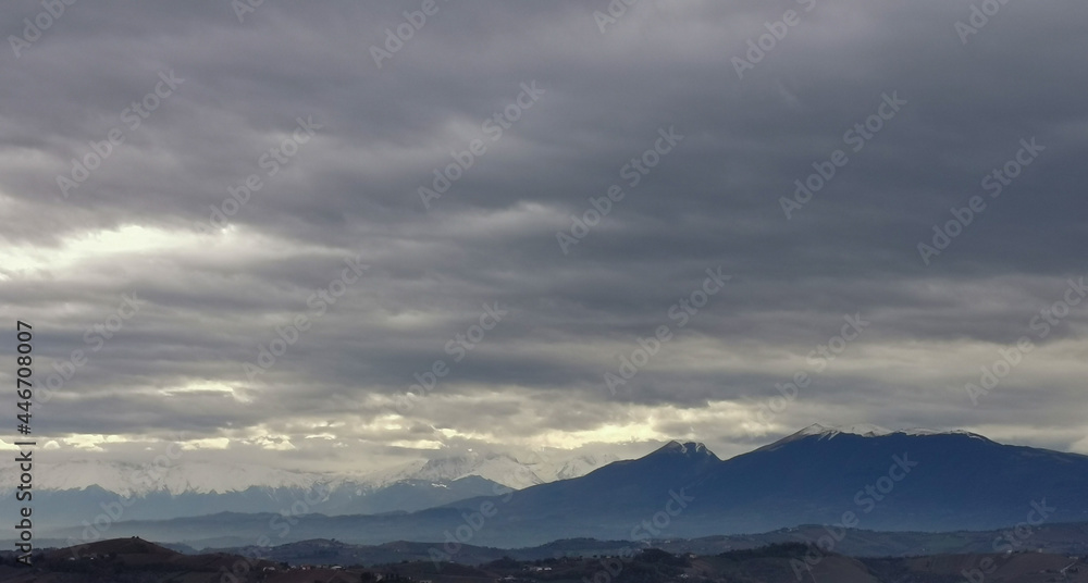 Nuvole grigie sopra le cime innevate dei monti Appennini