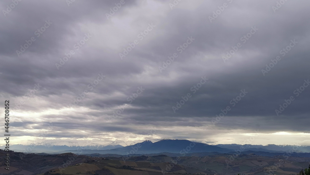 Nuvole grigie sopra le cime innevate dei monti Appennini