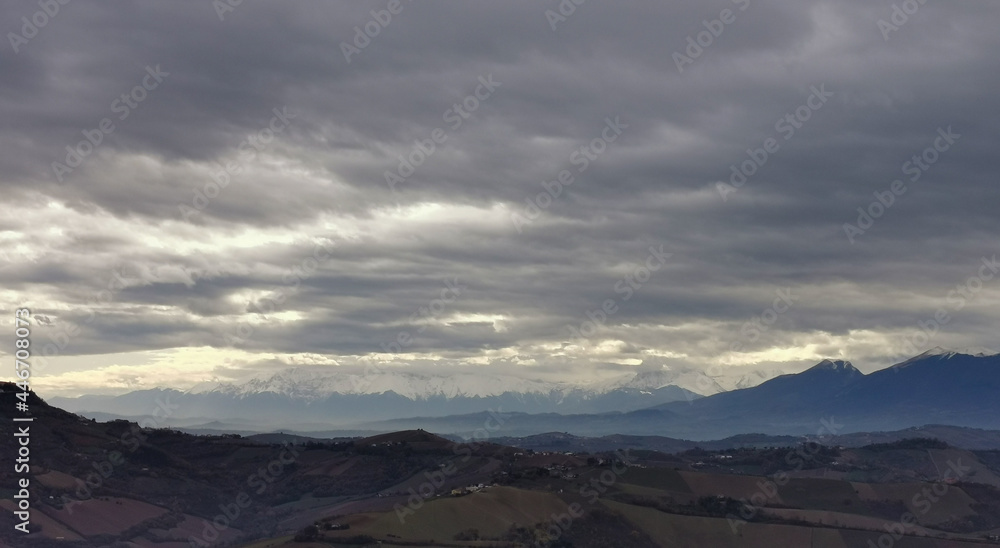 Nuvole grigie sopra le cime innevate dei monti Appennini