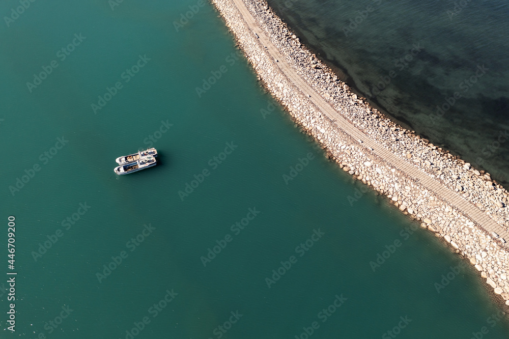 Road and boats on the lake. Shot in Sayram Lake in Xinjiang, China.