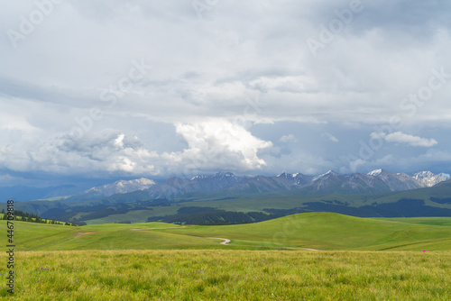 Grassland and mountains in a cloudy day. Photo in Kalajun grassland in Xinjiang, China. © Vink Fan