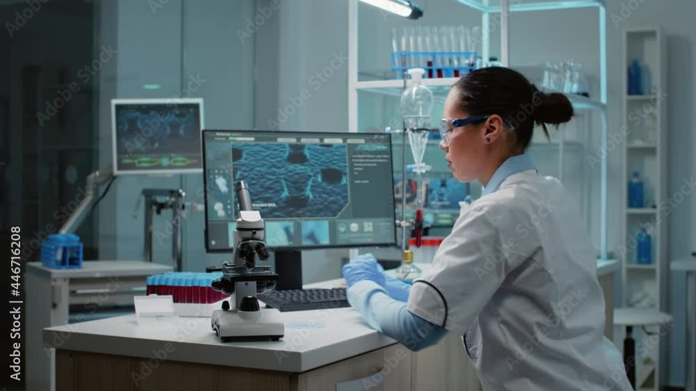 Biochemistry specialist doing research in laboratory with microscope, petri dish, vacutainers and analyzing dna animation on computer. Scientific woman looking at bacteria sample on plate Biochemistry specialist doing research in laboratory with microscope, petri dish, vacutainers and analyzing dna animation on computer. Scientific woman looking at bacteria sample on plate