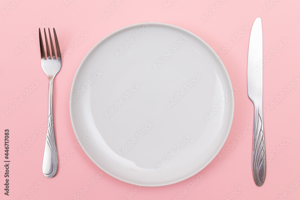 Empty White Ceramic Plate with Fork and Knife on Pink Background - Top View, Flat Lay Empty White Ceramic Plate with Fork and Knife on Pink Background - Top View, Flat Lay