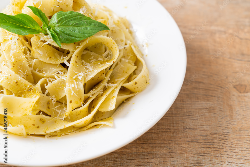 pesto fettuccine pasta with parmesan cheese on top