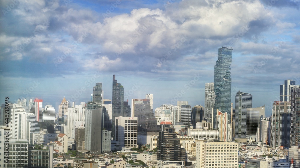 a beautiful cityscape of high buildings in central business district of Bangkok with moving clouds in the background