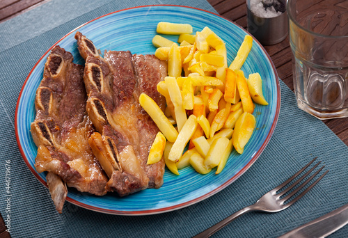 Traditional Galician churrasco - grilled beef short ribs served with crispy fried potatoes photo