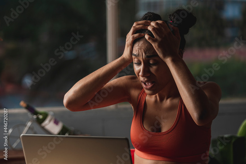 mujer morena sorprendida y muy asustada con su computadora haciendo tele trabajo  photo