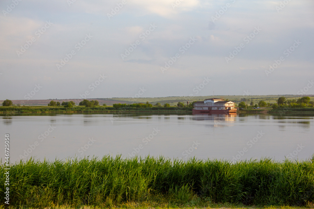 A serene rural landscape in the hinterland. Calm river at dawn, pier, landing stage waiting for the ship. A serene rural landscape in the hinterland. Calm river at dawn, pier, landing stage waiting for the ship.