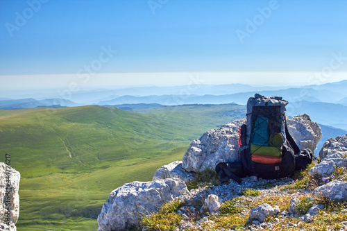 Gray backpack on the background of mountains and fields