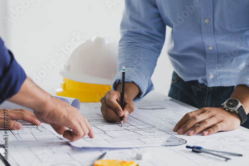 engineer meeting for an architectural project. working with partner and engineering tools working on blueprint architectural project at the construction site at desk in the office.