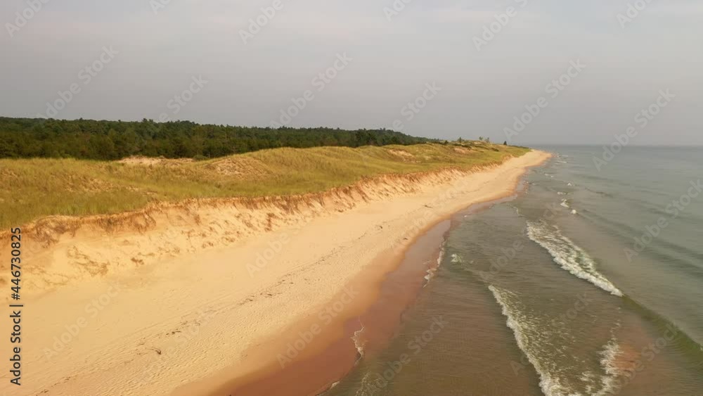 The shoreline of Lake Michigan In Ludington State Park, Michigan, United States. Aerial view, flying over sand beach. Sunset light The shoreline of Lake Michigan In Ludington State Park, Michigan, United States. Aerial view, flying over sand beach. Sunset light